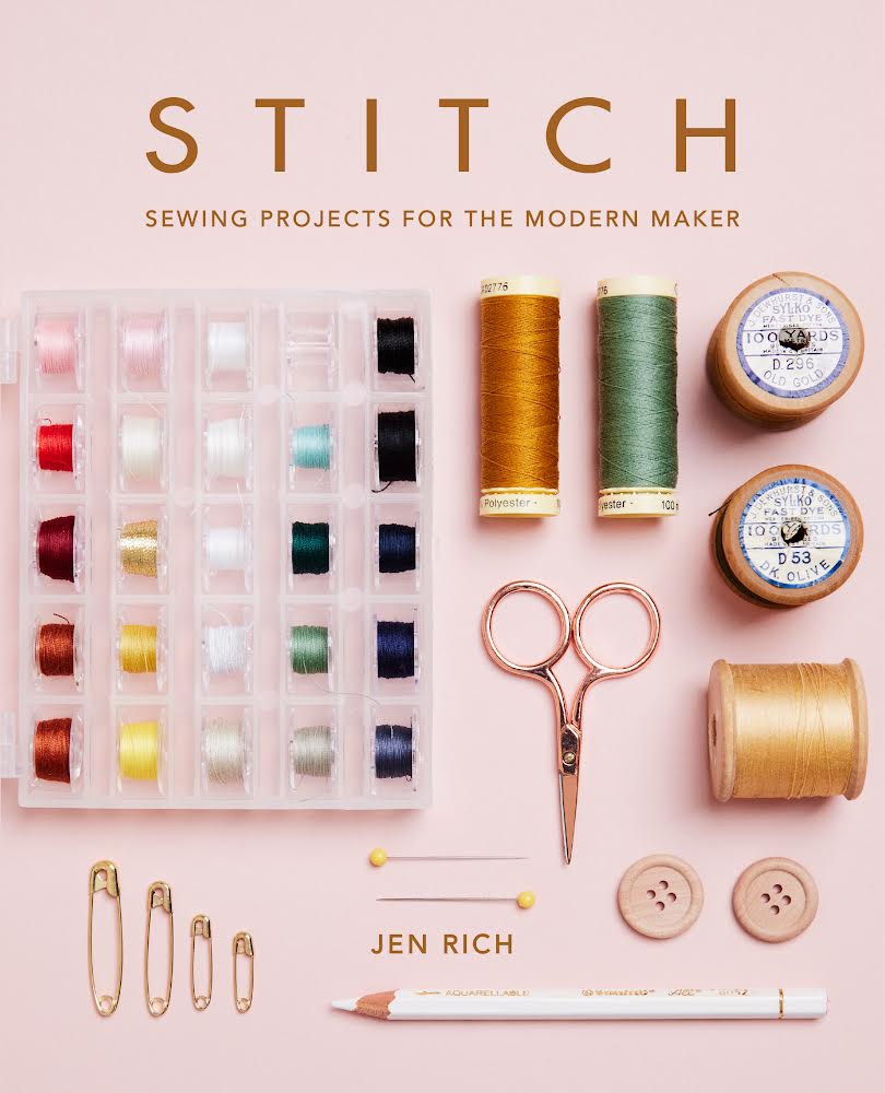 Book cover of Stitch: Sewing Projects for the Modern Maker. Cover is pale pink and shows spools of thread, scissors, pins, a chalk pencil and wooden buttons